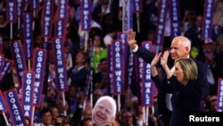 Calon wakil presiden dari Partai Demokrat AS Gubernur Minnesota Tim Walz dan istrinya Gwen melambaikan tangan di atas panggung pada Hari ke-3 Konvensi Nasional Demokrat (DNC) di United Center, di Chicago, Illinois, AS, 21 Agustus 2024. (Brendan Mcdermid/REUTERS)