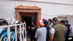 Local resident Sabah Hamed attends to migrants in the Spanish enclave of Ceuta, May 20, 2021. Spain says it has returned to Morocco over 6,600 migrants who swam or jumped over border fences into one of Spain's enclaves in North Africa this week.