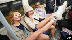 Underground riders display their bare legs as they take part in the annual event "No Trousers Tube Ride," in London, Jan. 12, 2025.