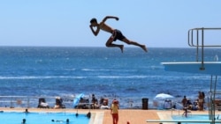 A person dives from a springboard during a hot summer day at Sea Point swimming pool in Cape Town, South Africa, Jan. 10, 2025. 