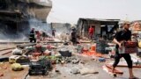 People gather at the site of a car bomb attack in Jamila market in Sadr City district of Baghdad, Iraq August 28, 2017. 