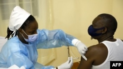 Un travailleur médical injecte une deuxième dose de vaccin Astrazeneca à un patient dans un centre de vaccination Covid-19 (coronavirus) à Kigali, le 27 mai 2021.