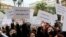 FILE - Women activists chant slogans and hold banners during a protest condemning violence against women and impunity, in Tunis, Tunisia on Friday, December 10, 2021. Banners in Arabic read: "Dig the graves and listen to the (killed) women".