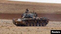 FILE - A Turkish army tank takes up position on the Turkish-Syrian border near the southeastern town of Suruc in Sanliurfa province, Sept. 29, 2014. 