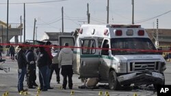 Forensic experts work on the scene after unknown gunmen opened fire on an ambulance, killing the driver, two patients and a relative of one of the patients in the northern border city of Ciudad Juarez, Mexico, December 7, 2011.