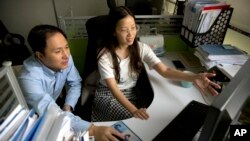 FILE - He Jiankui, left, and Zhou Xiaoqin work a computer at a laboratory in Shenzhen in southern China's Guangdong province, Oct. 10, 2018. 