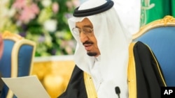 In this photo provided by the Saudi Press Agency, Saudi King Salman delivers his first major policy speech since assuming the throne in the al-Yamama palace, Riyadh, Saudi Arabia, March 10, 2015.