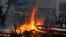 Police face a burning barricade during protests, Sept. 21, 2019, in Hong Kong. 