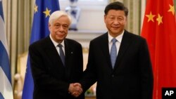 Presiden China Xi Jinping (kanan), dan Presiden Yunani, Prokopis Pavlopoulos, berjabat tangan menjelang pertemuan mereka di Istana Presiden Yunani di Athena, Senin, 11 November 2019. (Foto AP / Petros Giannakouris)
