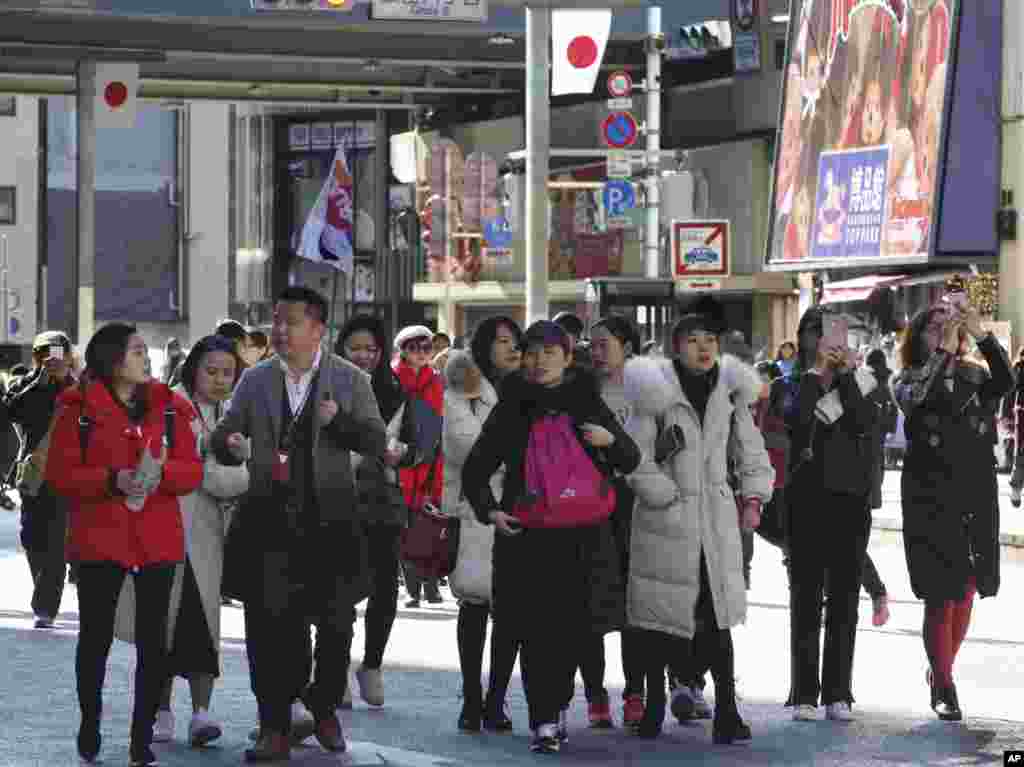 中国游客在2018年1月6日星期六东京银座购物区周围散步。