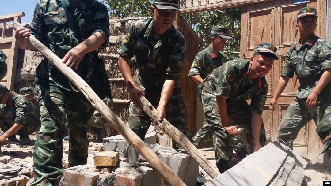 Rescuers help villagers dismantle damaged walls after a shallow 6.4-magnitude earthquake hit the area in Pishan county in Hetian, northeast China's Xinjiang region, July 3, 2015. 