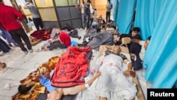 FILE - Wounded Palestinians lie on the floor as they are assisted at the Indonesian Hospital amid an Israeli air and ground offensive, in the northern Gaza Strip, Nov. 16, 2023.