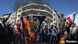 Iraníes queman la bandera estadounidense en Teherán, Irán, el 5 de abril de 2024, durante una manifestación que conmemora el Día de Quds y el funeral de los miembros del Cuerpo de la Guardia Revolucionaria Islámica que murieron en un presunto ataque aéreo israelí en Siria.