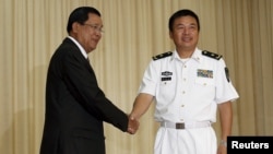 Yu Manjiang (R), commander officer of the Chinese fleet, is welcome by Cambodia's Prime Minister Hun Sen in Phnom Penh, Feb. 24, 2016. 