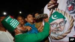 A Bangladeshi man throws a shoe at a Motiur Rahman Nizami poster to celebrate the execution of the Jamaat-e-Islami party's senior leader outside Dhaka's central jail, Bangladesh, early Wednesday, May 11, 2016.