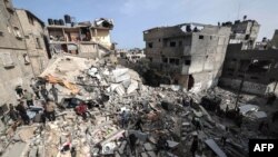 2024年3月27日，以色列与巴勒斯坦激进组织哈马斯之间的冲突还在继续，巴勒斯坦人检查以色列连夜轰炸加沙地带南部的拉法后被摧毁的建筑物废墟。
