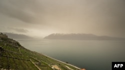 FILE—This photograph taken on March 30, 2024, shows thick sand dust blown in from the Sahara giving the sky a yellowish appearance above the vineyard terraces of Lavaux, on the banks of Lake Geneva, near Chexbres western Swizterland.