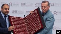 Turkey’s President Recep Tayyip Erdogan (R) receives a copy of the Quran, Islam's holy book, at an international students meeting in Istanbul May 16, 2015.