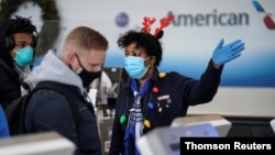 An airline worker in Christmas themed attire assists travelers at Ronald Reagan Washington National Airport in Arlington, Virginia
