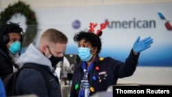 An airline worker in Christmas themed attire assists travelers at Ronald Reagan Washington National Airport in Arlington, Virginia.