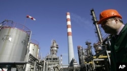 FILE - A worker is seen in the NIS Jugopetrol oil refinery, prior to a visit by Russian dignitaries, in Pancevo, Serbia, on Feb. 25, 2008.