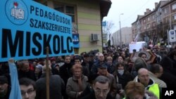 A protester holds a banner of the Teachers' Trade Union of Miskolc, during a teachers’ strike by Herman Otto Grammar School in Miskolc, 173 kms northeast of Budapest, Hungary, Feb. 3, 2016.