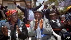 Seated left to right, Kenyans Jane Muthoni Mara, Wambogo Nyingi and Paulo Muoka Nzili celebrate the announcement of a legal decision in support of Mau Mau veteran reparation payments in Nairobi in this October 5, 2012, file photo.