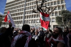 Anti-government protesters chant slogans during protests against the Lebanese government in front of the Central Bank, in Beirut, Lebanon, Feb. 1, 2020.