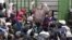 FILE: An immigration official addresses Zimbabweans outside an immigration office in downtown Johannesburg, South Africa, December 15, 2010, as they attempt to become legal. 