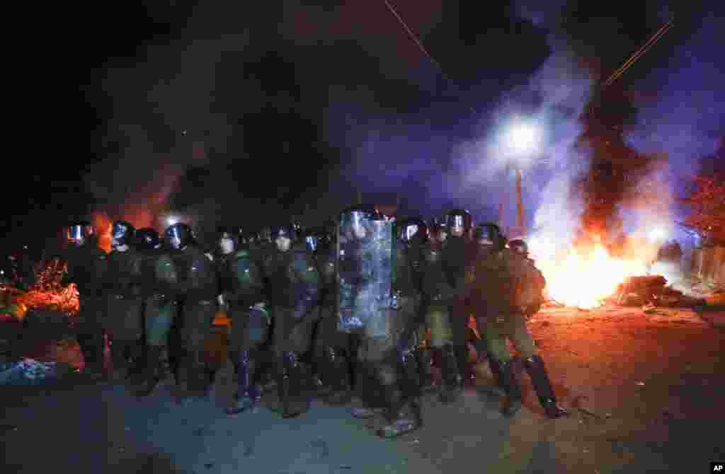 Ukrainian riot police prepare to push back demonstrators, who planned to stop buses carrying passengers evacuated from the Chinese city of Wuhan, outside Novi Sarzhany, to protest against their arrival.