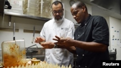 Executive chef Miguel Aguilar (L) shows chef Michael Alejandro Calvo Oviedo of El Atelier restaurant in Havana, Cuba, how to make chicken ropa vieja empanadas at Wynwood Kitchen & Bar in Miami, Florida, Aug. 13, 2015.