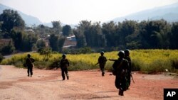 FILE - Myanmar army soldiers carrying weapons patrol on a road as part of operations against ethnic rebels, in Kokang, northeastern Shan State, more than 800 kilometers (500 miles) northeast of Yangon, Myanmar.