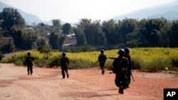 FILE - Myanmar army soldiers patrol a road in Feb. 2015 as part of operations against ethnic rebels in Kokang, northeastern Shan State, Myanmar.