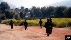 FILE - Myanmar army soldiers carrying weapons patrol on a road as part of operations against ethnic rebels, in Kokang, northeastern Shan State, more than 800 kilometers (500 miles) northeast of Yangon, Myanmar.