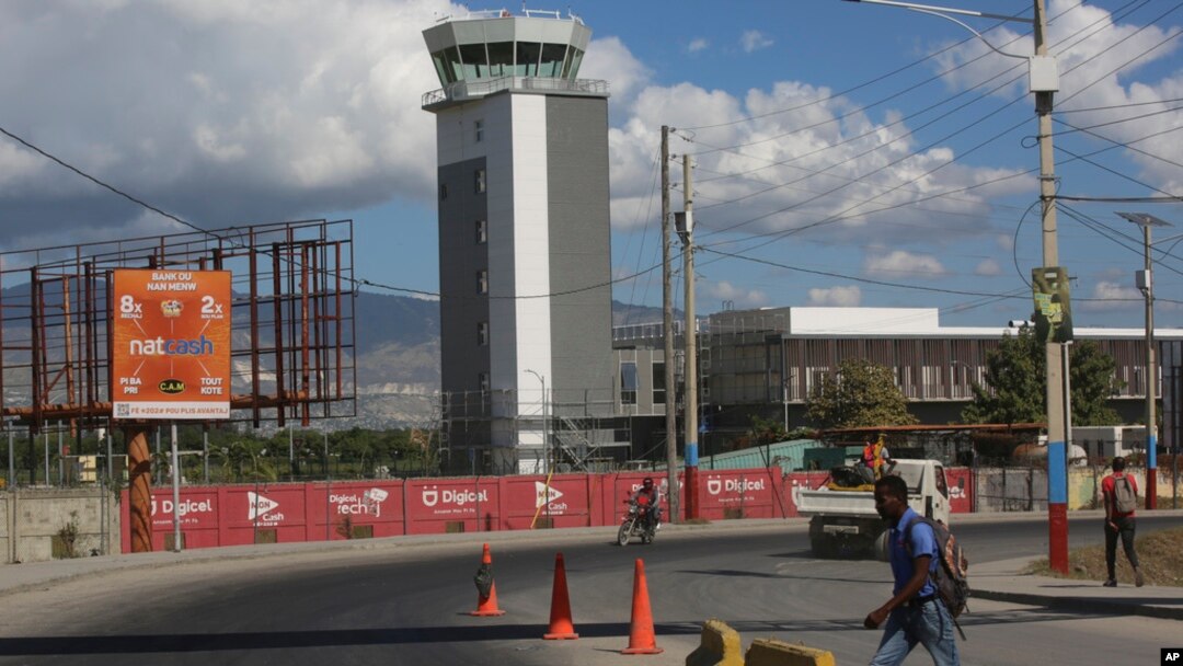 People walk past the Toussaint Louverture International Airport on the day it reopened in Port-au-Prince, Haiti, Dec. 11, 2024.