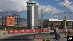 People walk past the Toussaint Louverture International Airport on the day it reopened in Port-au-Prince, Haiti, Dec. 11, 2024.