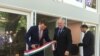 Hungarian State Secretary for Economic Strategy László György, left, cuts a ribbon, styled after the Hungarian flag, as Ambassador László Szabó, center, looks on at the opening ceremony of a business promotion center in Washington, June 12, 2019.