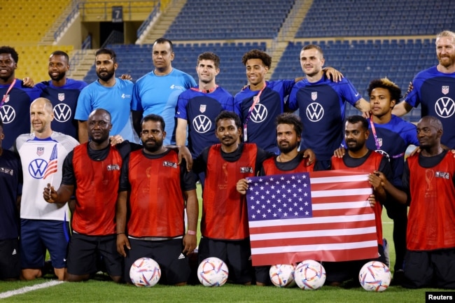 Christian Pulisic of the U.S. and teammates pose with players from a construction workers team on November 15, 2022. (REUTERS/Kai Pfaffenbach)