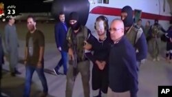 In this frame grab from Egyptian State Television, a blindfolded Hisham el-Ashmawi, a prominent Egyptian militant is escorted by Egyptian military officers and placed in a vehicle after being taken off a military plane at an airport in Cairo, May 29, 2019.