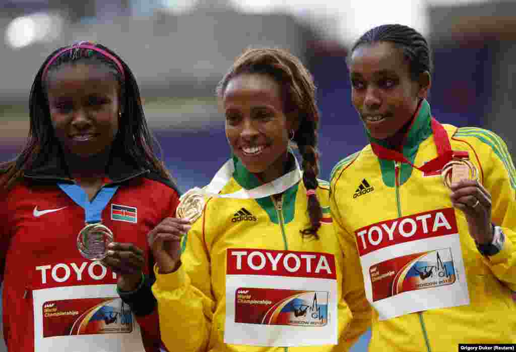 Mshindi wa medali ya dhahabu Meseret Defar wa Ethiopia (kati) akiwa pamoja na mshindi wa medali ya fedha t Mercy Cherono wa Kenya (kushoto) na mshindi wa shaba Almaz Ayana wa Ethopia wakati wa mbiyo za mita 5,000 wanawake wakati wa sherehe za ushindi kwenye uwanja wa Luzhniki, Moscow.