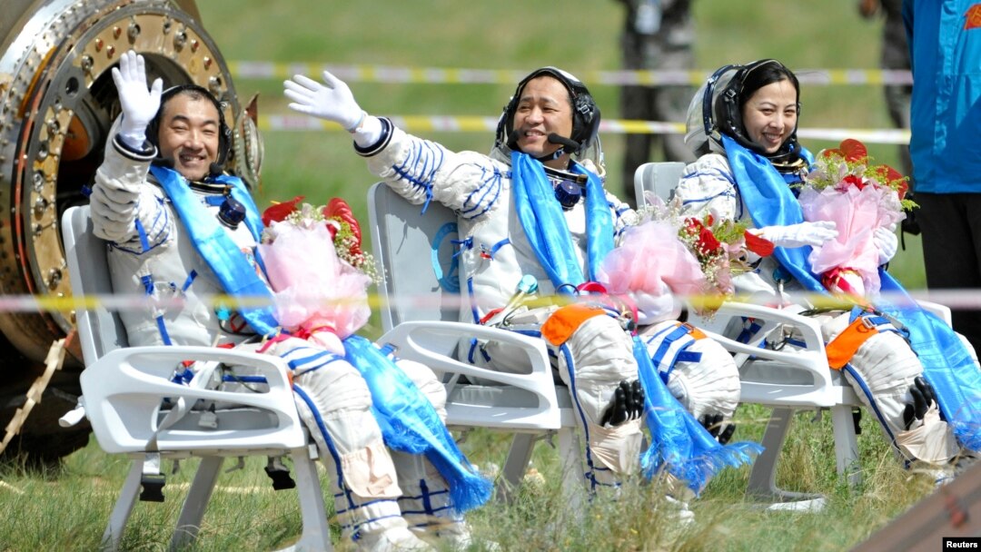 Astronot China (dari kiri) Zhang Xiaoguang, Nie Haisheng dan Wang Yaping melambaikan tangannya sesaat setelah mendarat dengan kapsul yang dibawa oleh pesawat antariksa Shenzhou-10 di wilayah Mongolia, China (26/6).