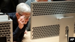 تیم کوک، مدیر عامل اپل، در سالن عرضه در کنفرانس اپل در کالیفرنیا به صفحه نمایش یک کامپیوتر مک پرو نگاه می‌کند.