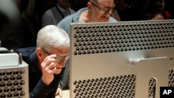 Jeff Chiu Description: Apple CEO Tim Cook, left, and chief design officer Jonathan Ive look at a Mac Pro in the display room at the Apple Worldwide Developers Conference in San Jose, Calif., June 3, 2019. 