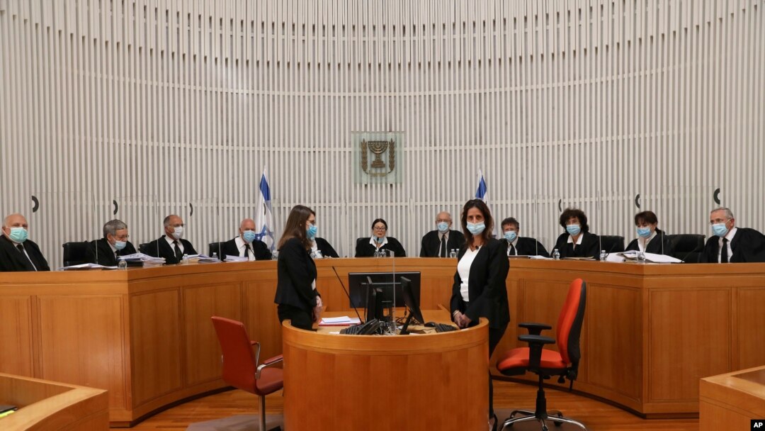 A panel of 11 Israeli Supreme Court judges wearing face masks hear arguments against the legality of Prime Minister Benjamin Netanyahu’s coalition deal, at the Israeli Supreme Court in Jerusalem, May 4, 2020.