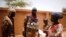 Malian Armed Forces (FAMa) soldiers speak with a woman during the Operation Barkhane in Ndaki, Mali, July 29, 2019. 