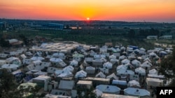 The sun sets in Egypt across the border from the southern Gaza Strip near tents housing Palestinians displaced by the conflict in Gaza, in Rafah in the southern Gaza Strip on Dec. 18, 2023.