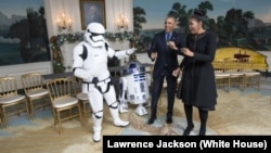 Le président Barack Obama et la Première dame Michelle Obama danse avec un stormrooper et R2-D2 de Star Wars dans la salle de réception diplomatique de la Maison Blanche,18 décembre 2015.