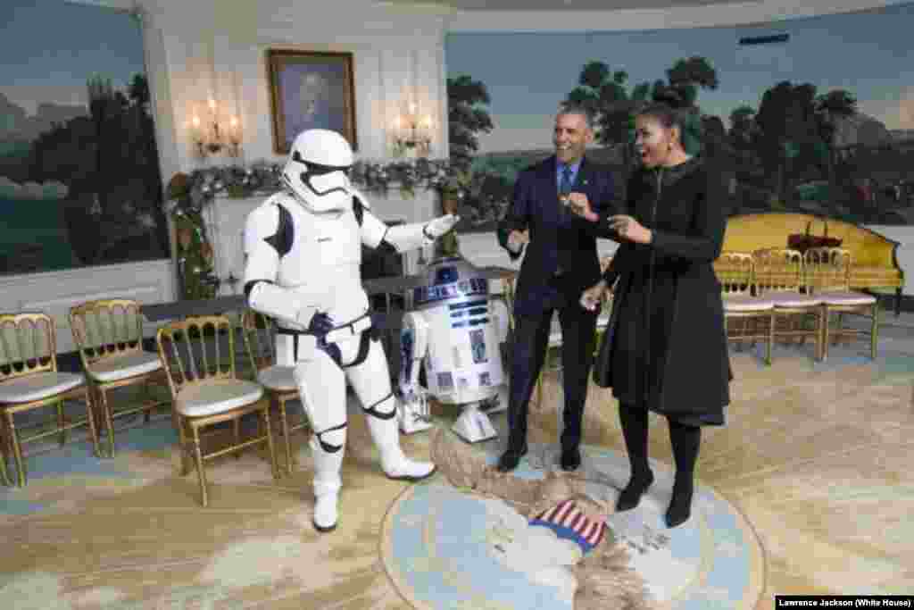 President Barack Obama and first lady Michelle Obama dance with a stormtrooper and R2-D2 from Star Wars, in the Diplomatic Reception Room of the White House, Dec. 18, 2015.