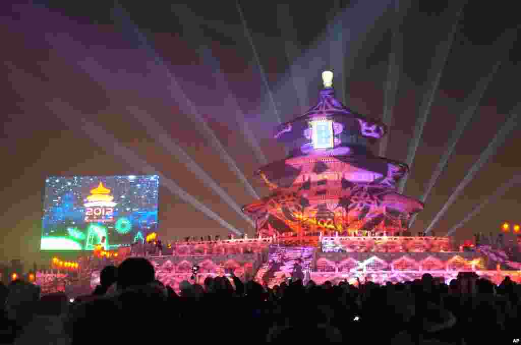 People gather to celebrate the new year 2012 at the illuminated Temple of Heaven, the city's historic landmark in Beijing on January 1, 2012. Billions marked the end of 2011 with noisy celebrations from Sydney to Stockholm. (AFP)