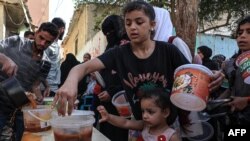 Anak-anak Palestina antre untuk menerima pembagian makanan di dapur amal darurat di Rafah di Jalur Gaza selatan, di tengah pertempuran yang sedang berlangsung antara Israel dan kelompok militan Hamas.